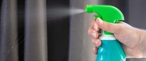 Hand holding disinfectant and spraying it