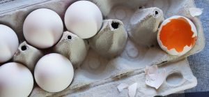 Carton of eggs with one broken egg