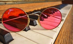Spectacles with red lenses on a piano