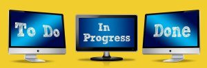 Three monitors displaying to do, in progress and done