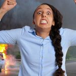Angry woman with a burning car in the background