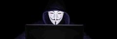 Hacktivism - anonymous masked hacker at a computer