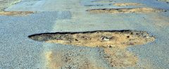 Photo of a road with potholes